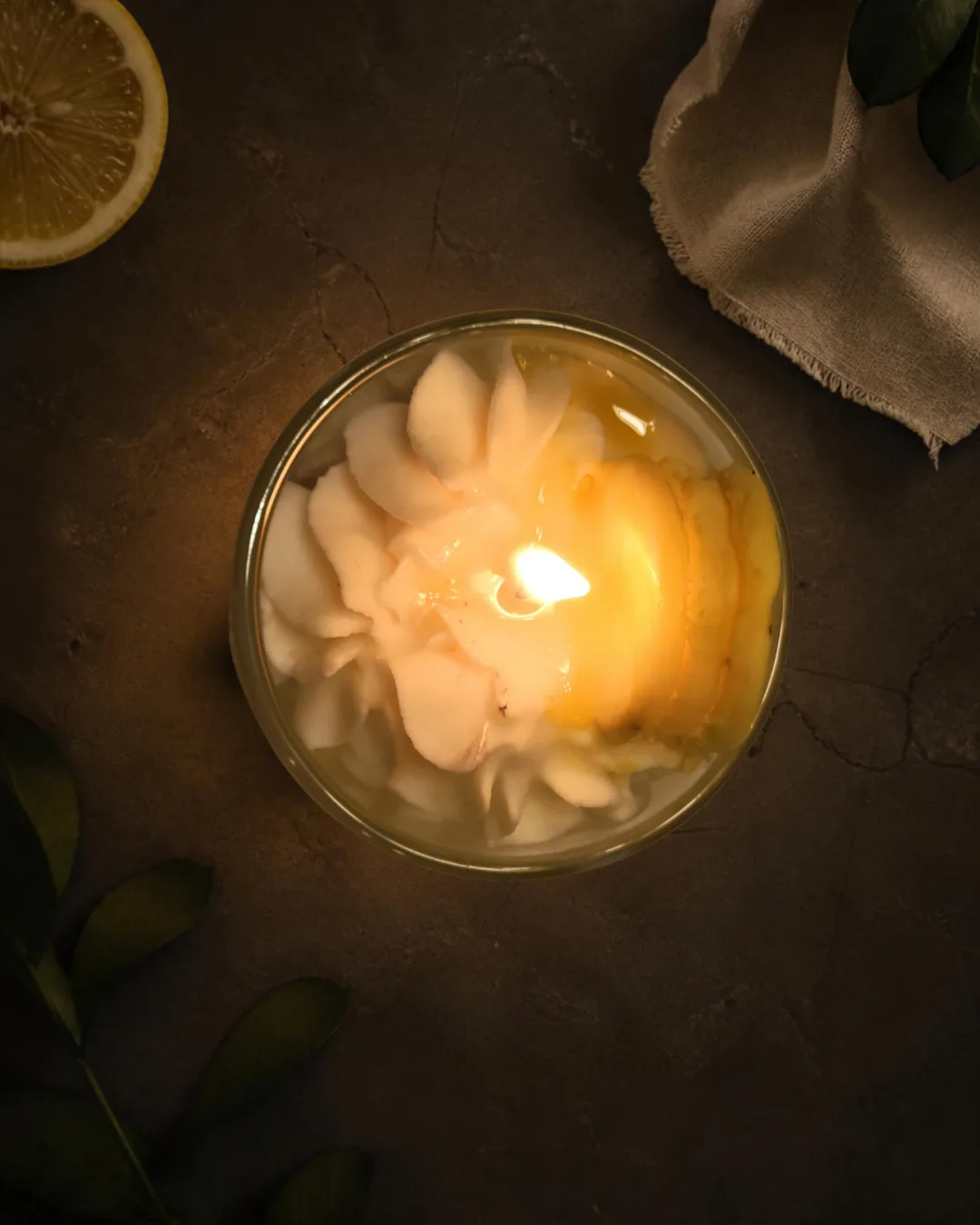 Top view of burning Lemon Macaron Creme candle with glowing decorative wax