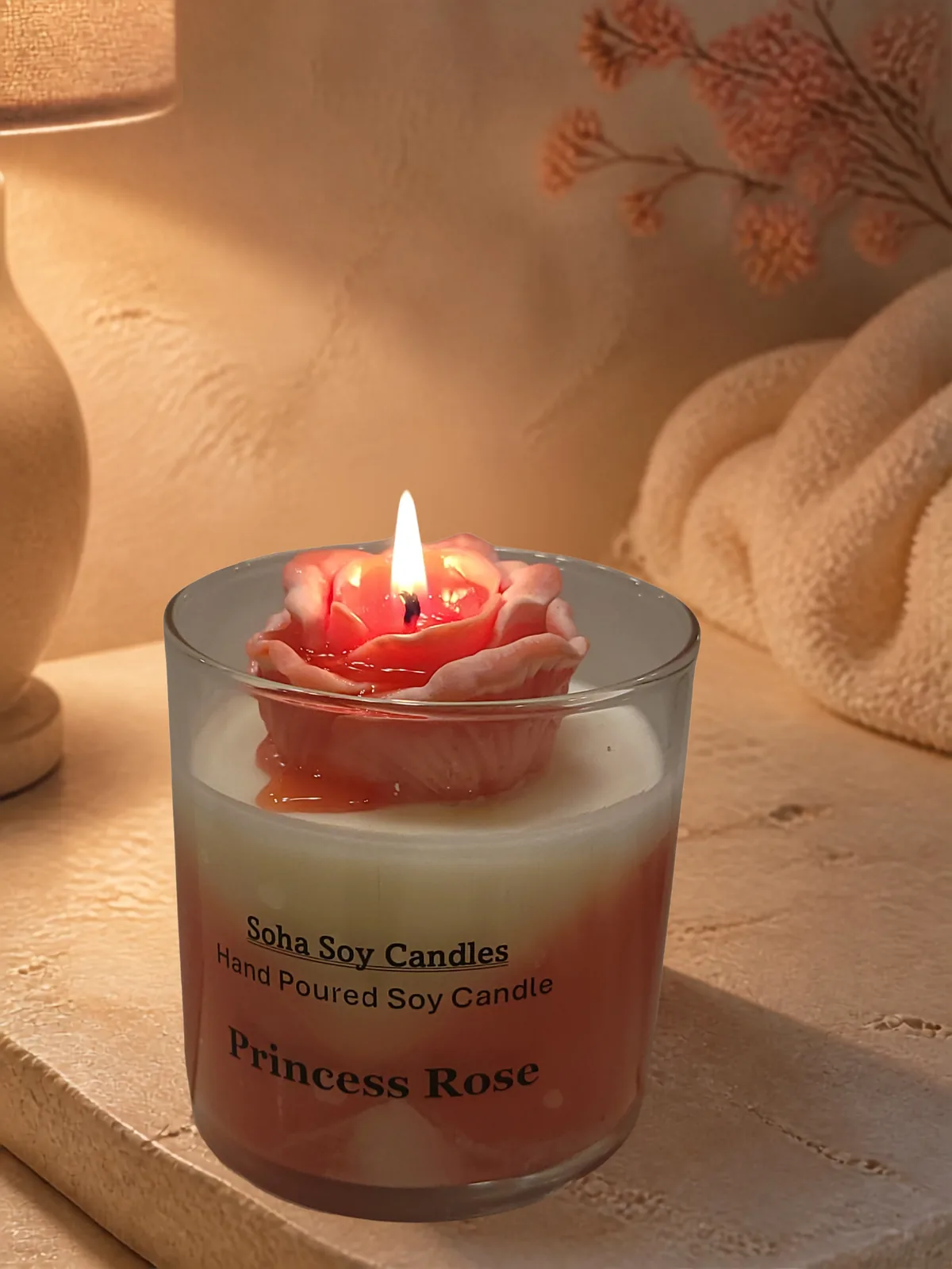 Burning Princess Rose candle with a glowing wax rose topper
