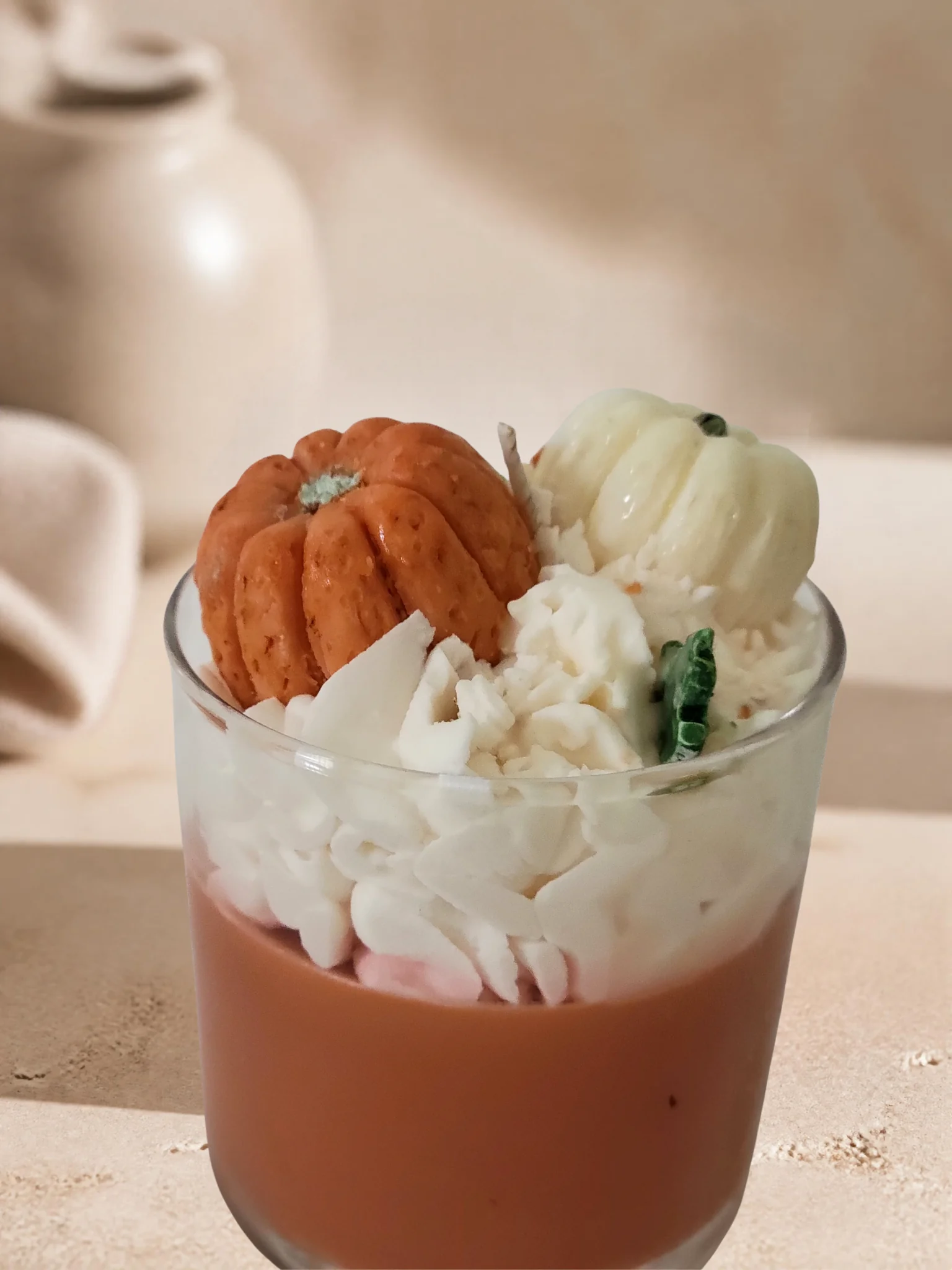 Side view of orange pumpkin spice soy candle with fall wax toppers