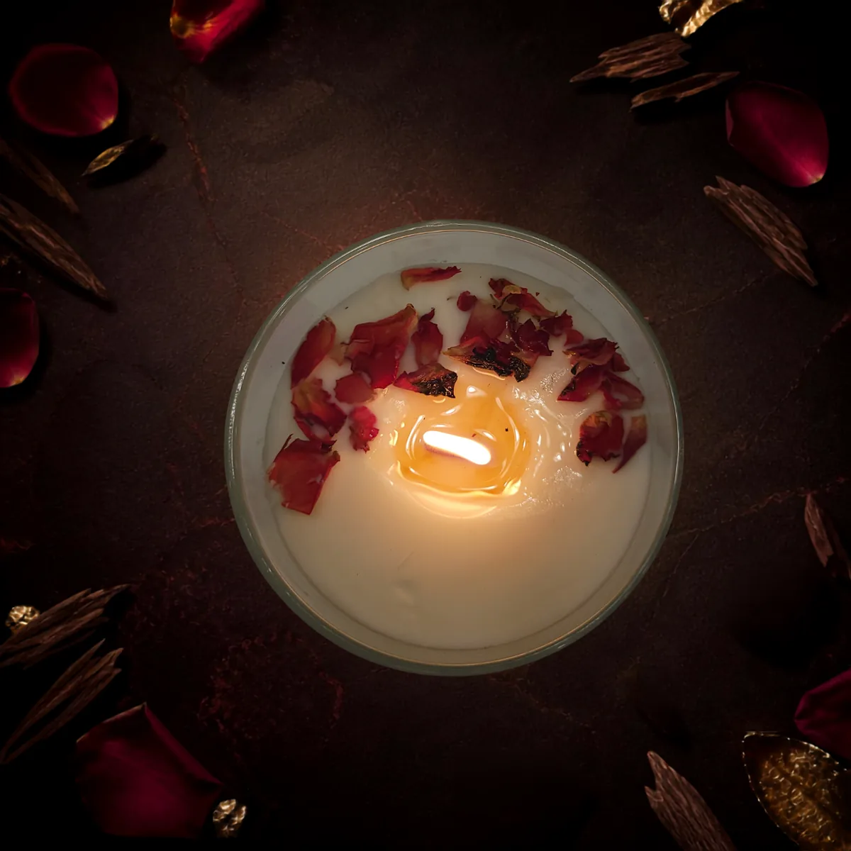 Top view of burning Velvet Rose and Oud candle with glowing rose petals
